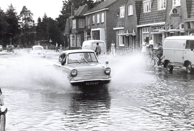 92332 Afbeelding van de wateroverlast aan de zuidzijde van de Hessenweg te De Bilt; met een auto rijdend door het water.